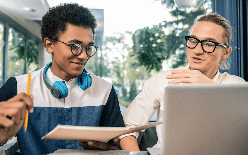 Student studying with teacher on computer in classroom